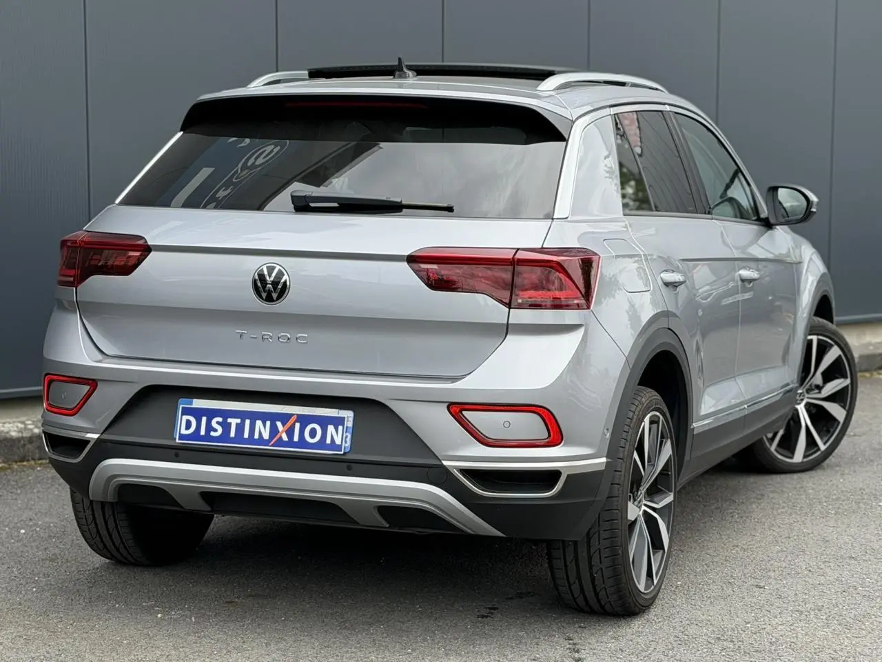Vue 3/4 arrière droite d’un Volkswagen T-Roc argent pyrite avec jantes alliage 19 pouces et vitres arrière surteintées.