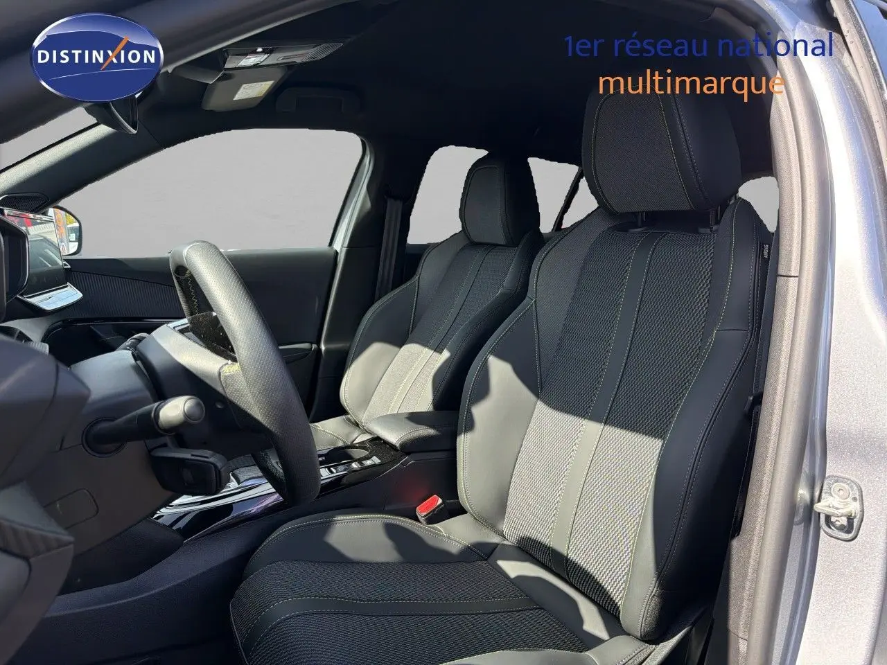 Vue intérieure côté conducteur du Peugeot 2008 1.2 HYBRID 145 GT gris Artense, sièges en cuir noir avec surpiqûres contrastées.