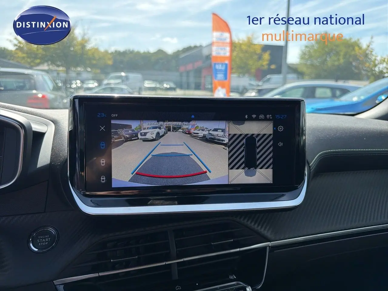 Vue intérieure du tableau de bord du Peugeot 2008 gris Artense, écran tactile affichant la caméra de recul et l'aide au stationnement.