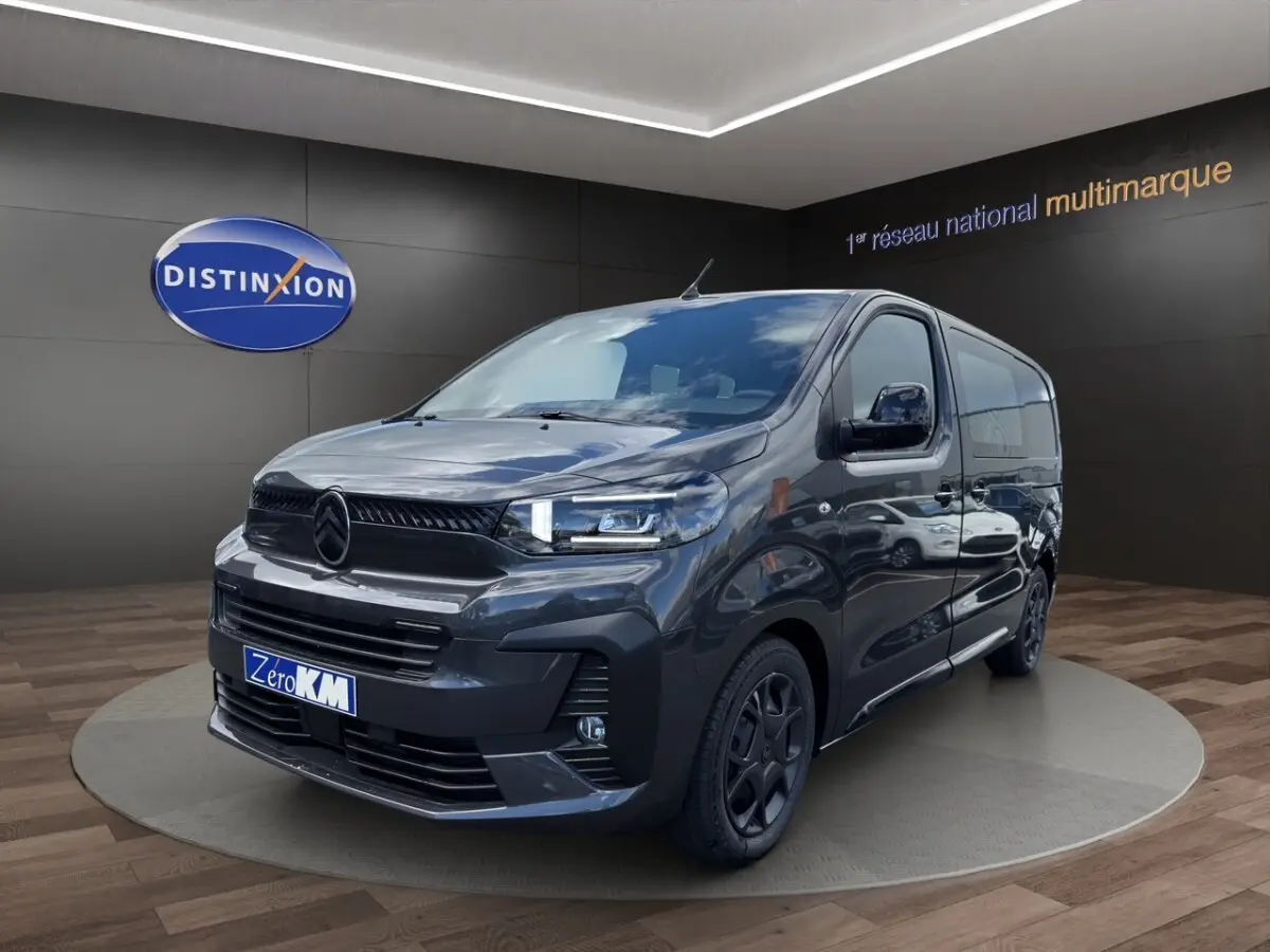Vue 3/4 avant droit d’un Citroën Jumpy gris foncé avec calandre noire et jantes sombres, en showroom.