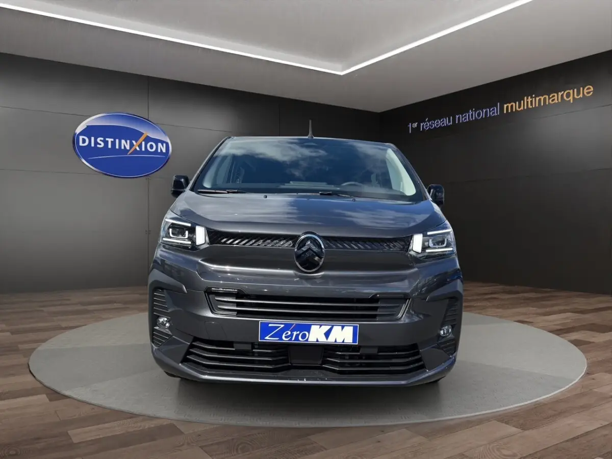 Vue avant d'un Citroën Jumpy gris foncé avec calandre noire et phares LED dans un showroom.