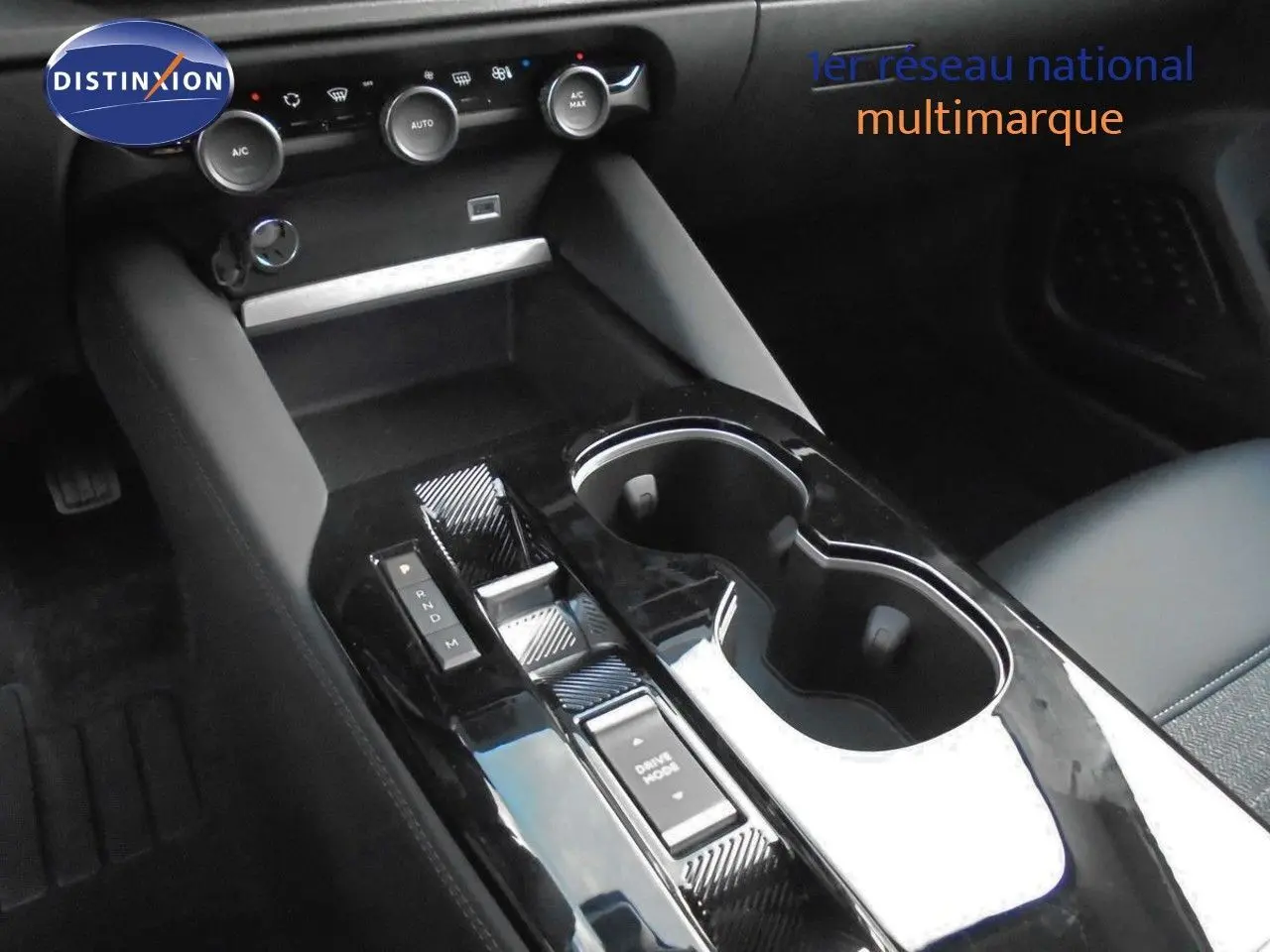 Vue rapprochée de la console centrale noire brillante avec sélecteur de boîte auto et commandes climatisation d'une Citroën C5 X 2022.