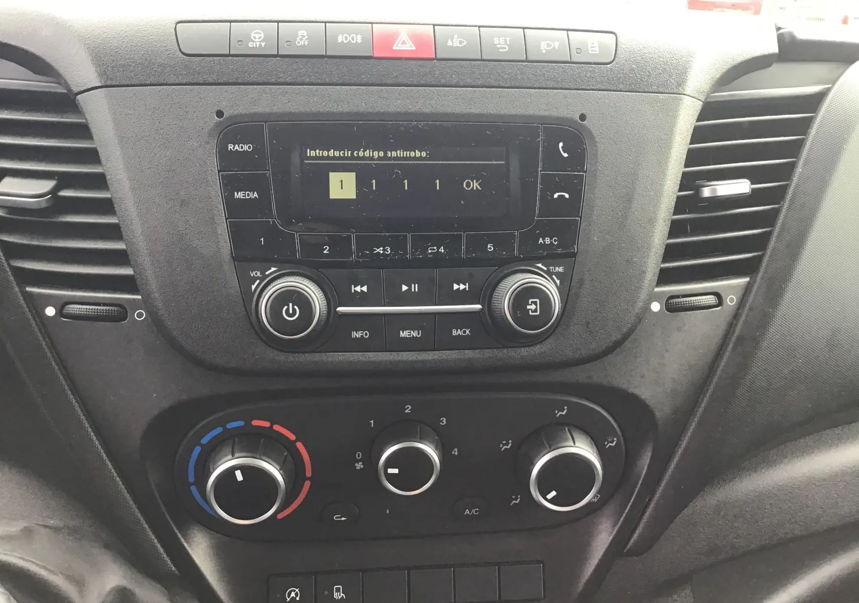 Tableau de bord central du fourgon Iveco Daily blanc 2022 avec commandes radio et climatisation visibles.