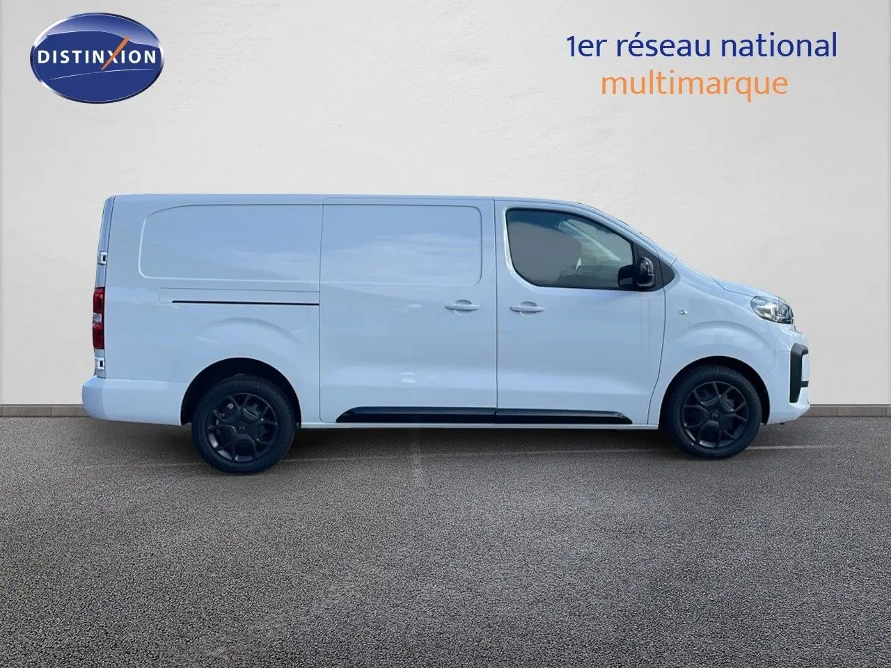 Profil droit du Citroën Jumpy Fourgon XL blanc Kaolin avec jantes noires et portes coulissantes.