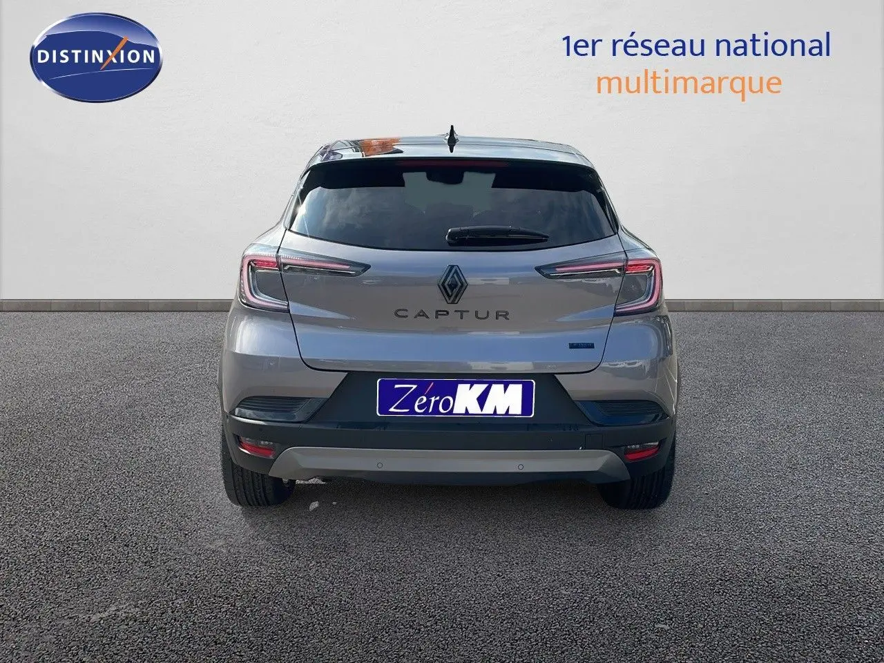 Vue arrière d'un Renault Captur gris cassiopée métal avec toit noir, modèle hybride 2025, sur fond neutre.
