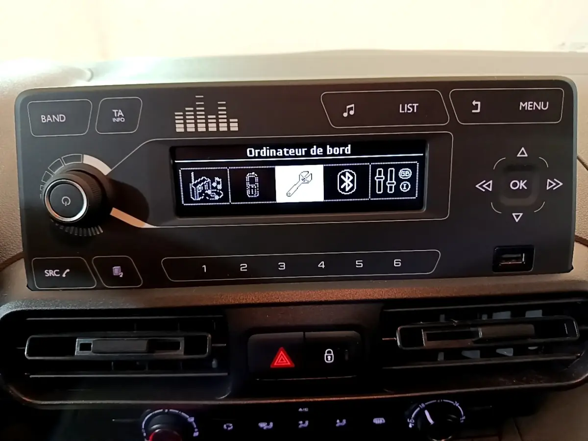 Tableau de bord du Citroën Berlingo 2021, affichage numérique central avec commandes audio et climatisation visibles.