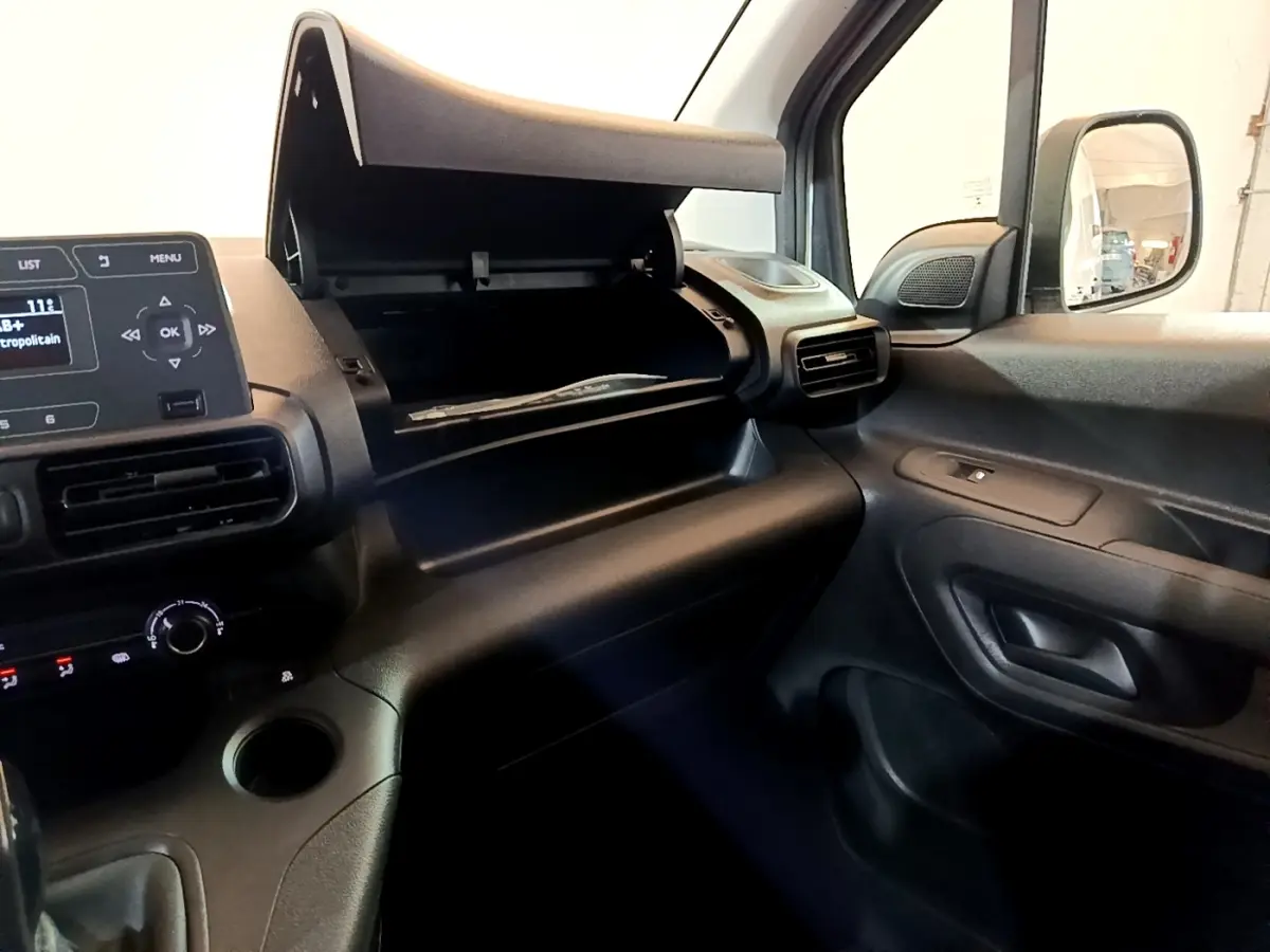 Intérieur du Citroën Berlingo 2021, vue côté passager avec boîte à gants ouverte et tableau de bord noir.