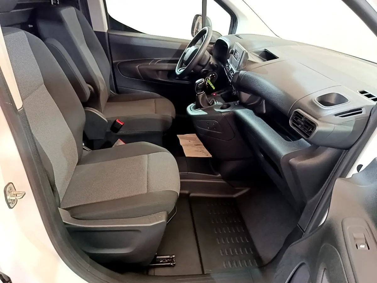 Intérieur avant du Citroën Berlingo blanc 2021, sièges gris et tableau de bord avec console centrale visible.