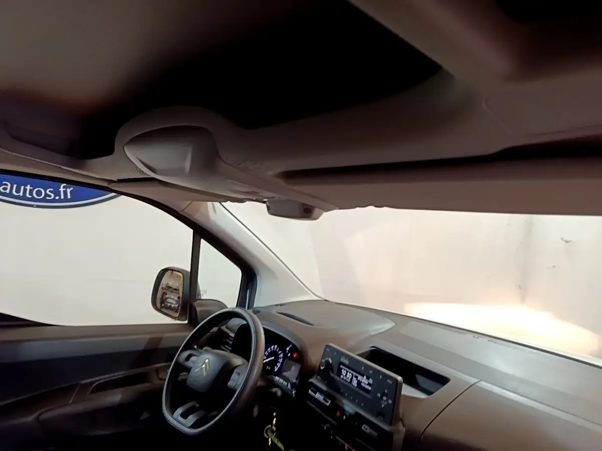 Vue intérieure côté conducteur du tableau de bord et volant du Citroën Berlingo blanc 2021 avec écran tactile central.