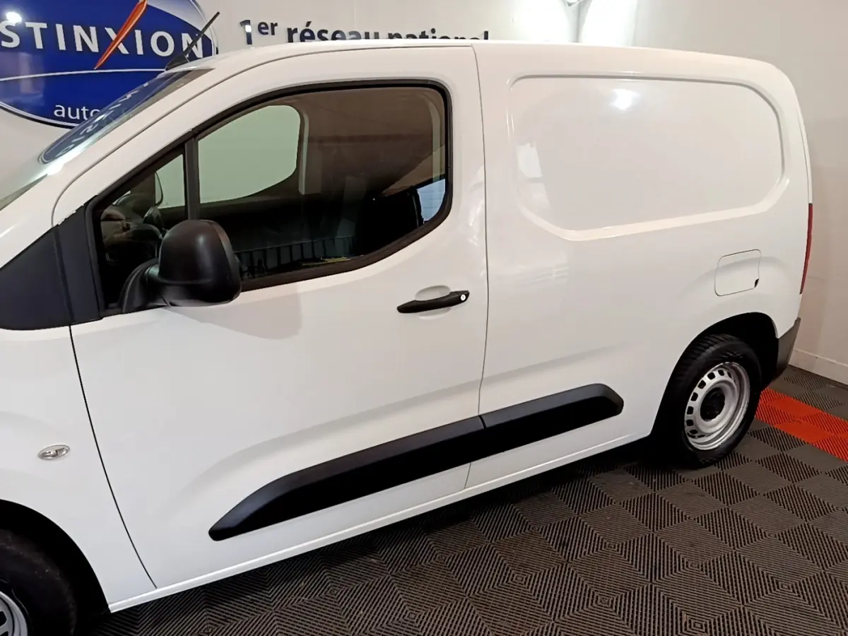 Profil côté gauche d’un utilitaire blanc Citroën Berlingo M 650kg avec poignée noire et jante acier simple.