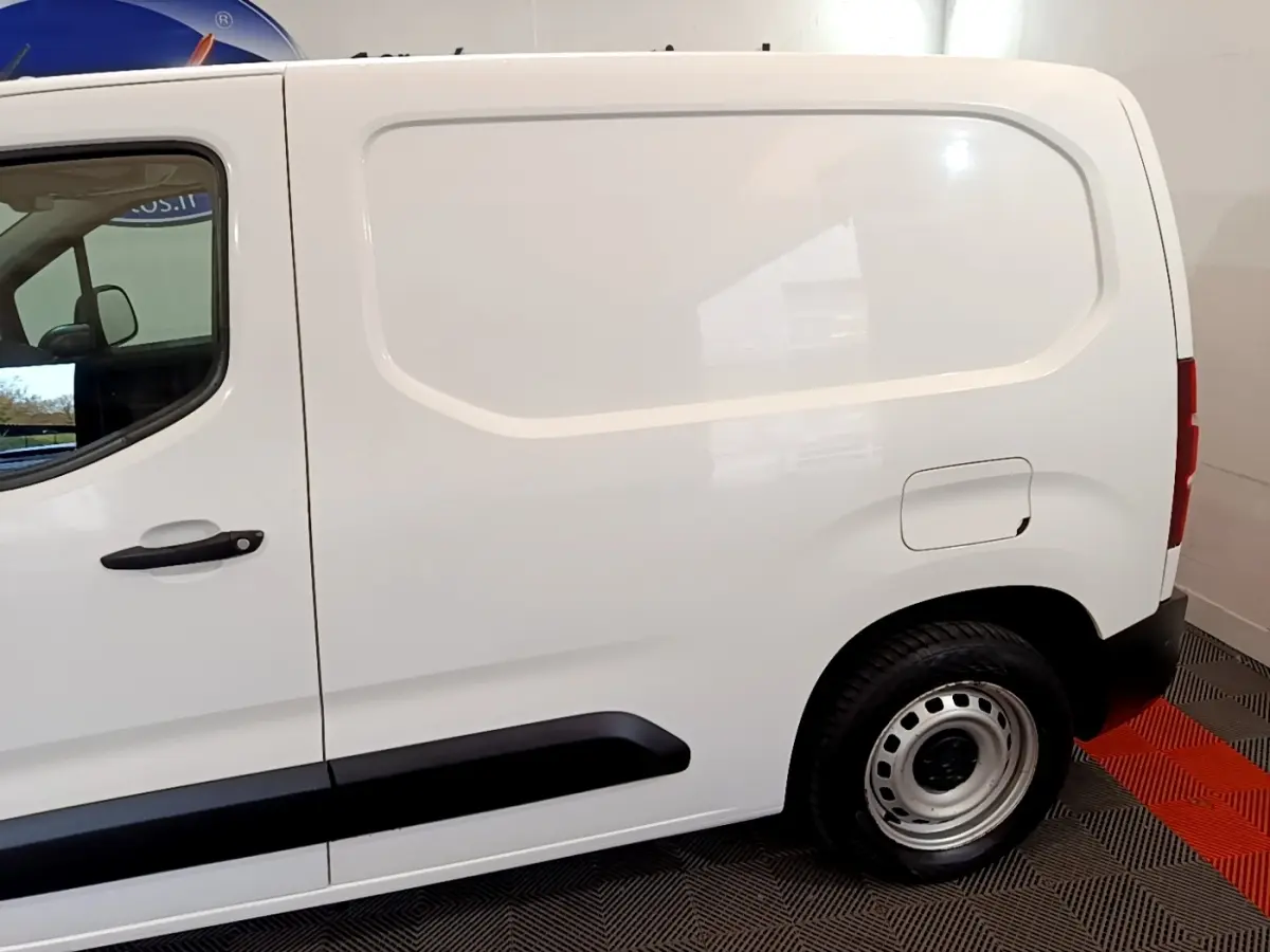 Vue latérale droite d'un utilitaire Citroën Berlingo blanc avec cloison pleine et jantes acier simples.