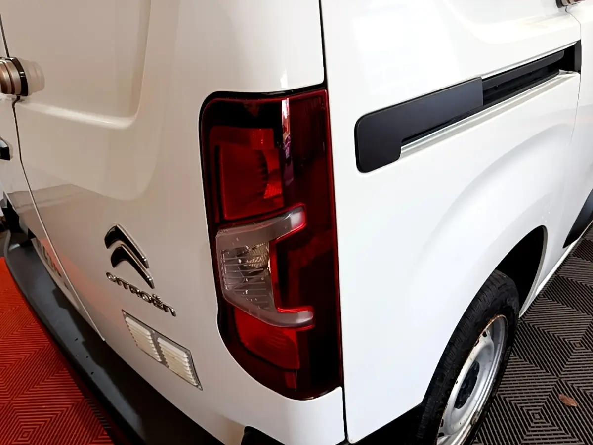 Vue arrière droite d'un utilitaire Citroën Berlingo blanc avec feu arrière rouge et jante acier simple.