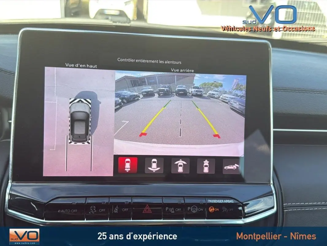 Écran tactile intérieur montrant la caméra de recul et la vue en hauteur du Jeep Compass blanc 2024.