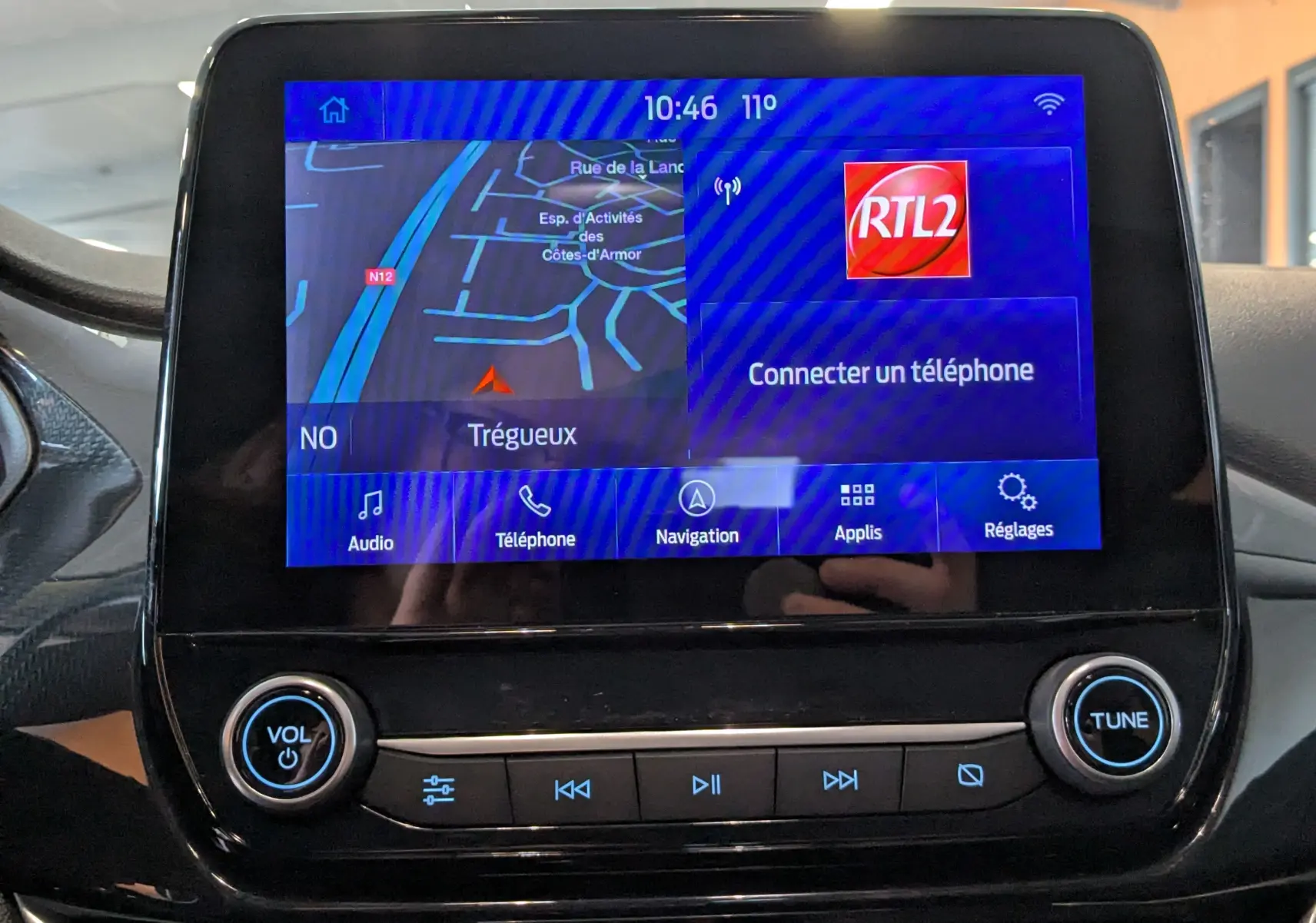 Écran tactile central du Ford Puma gris 2020 affichant la navigation et la radio RTL2, avec commandes volume et réglages visibles.