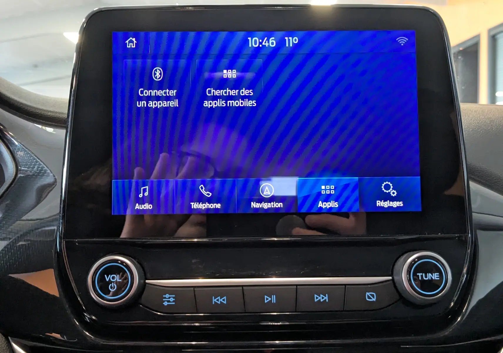 Écran tactile central de la Ford Puma 2020 gris, affichant le menu principal avec options audio, téléphone et navigation.