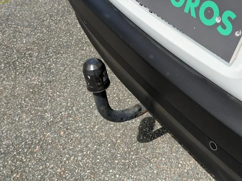 Gros plan sur l'attelage arrière noir d'une Citroën C3 blanche Banquise, avec pare-chocs noir mat et capteur de recul.