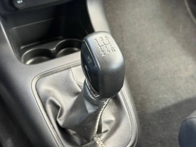 Gros plan sur le levier de vitesses manuel noir de la Citroën C3 PureTech 82ch Feel, intérieur gris et console centrale.