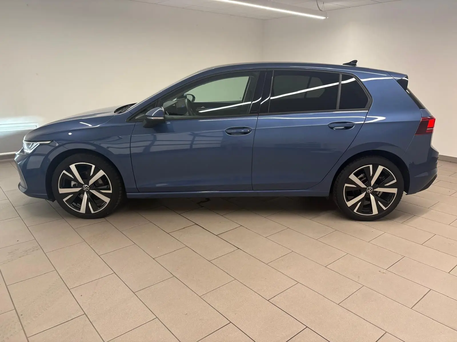 Vue de profil côté gauche d'une Volkswagen Golf 1.5 TSI 116 BVM6 Bleu Anémone avec jantes alliage 18 pouces Catania.