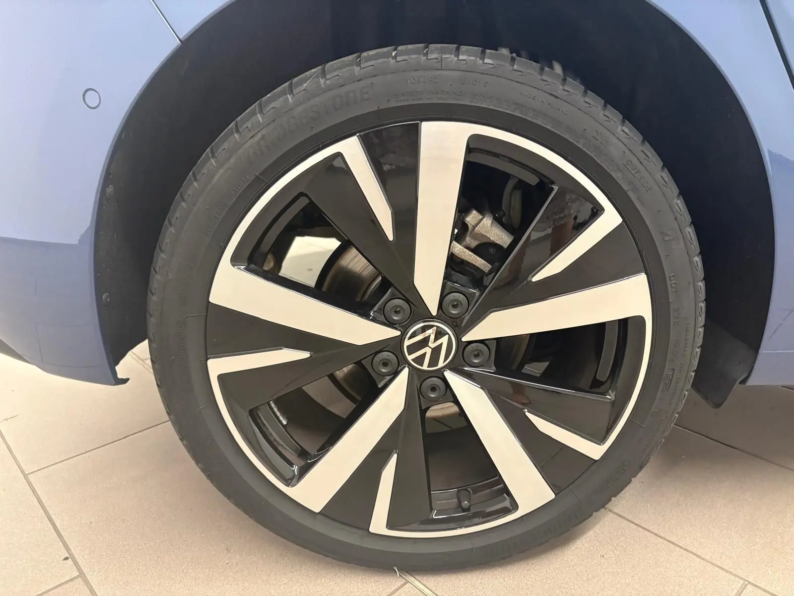 Gros plan sur la jante alliage 18'' Catania noir et argent d'une Volkswagen Golf Bleu Anémone, côté arrière droit.