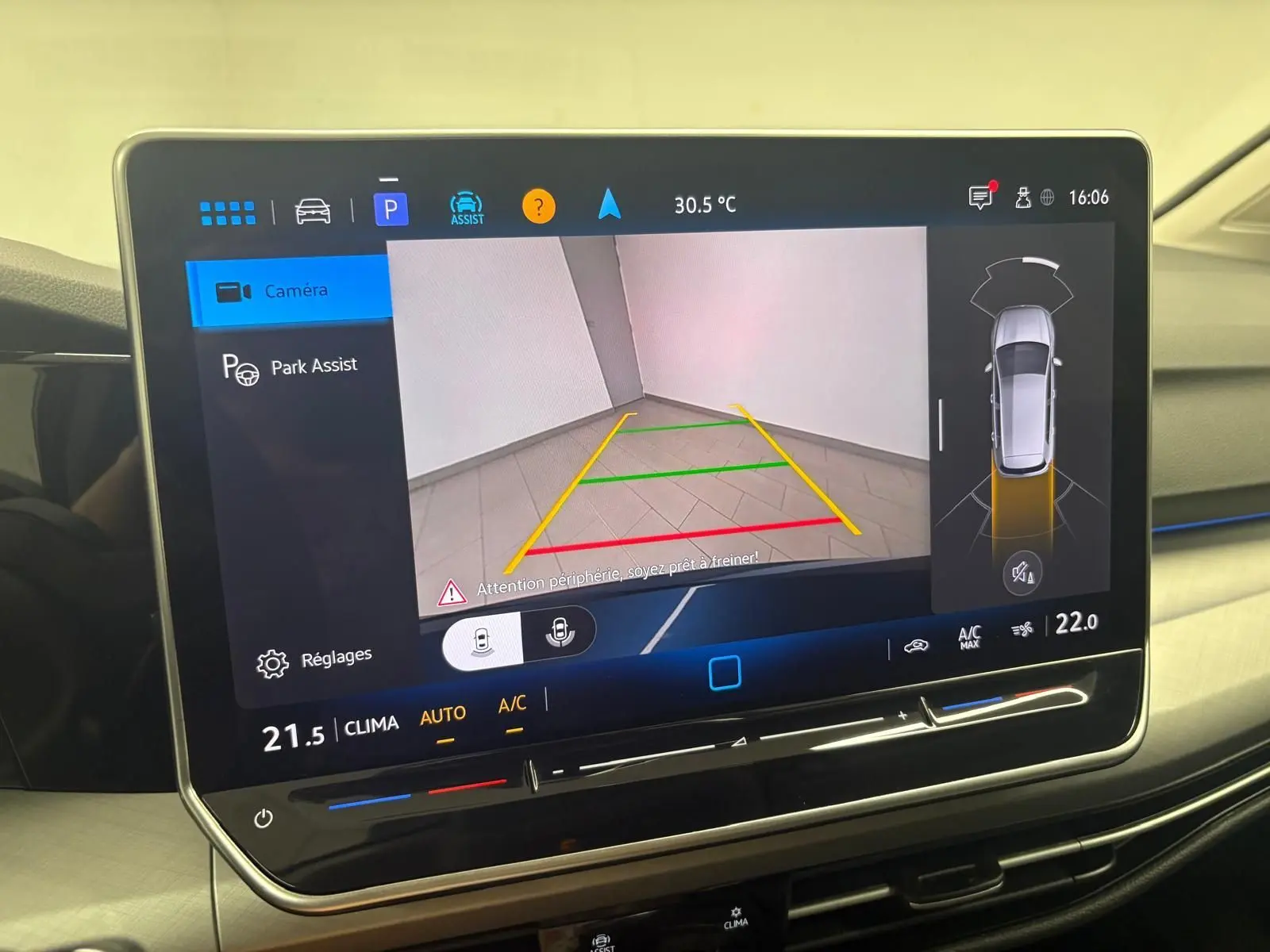 Écran tactile intérieur de Volkswagen Golf 2025 montrant l'assistance au stationnement avec caméra de recul active.