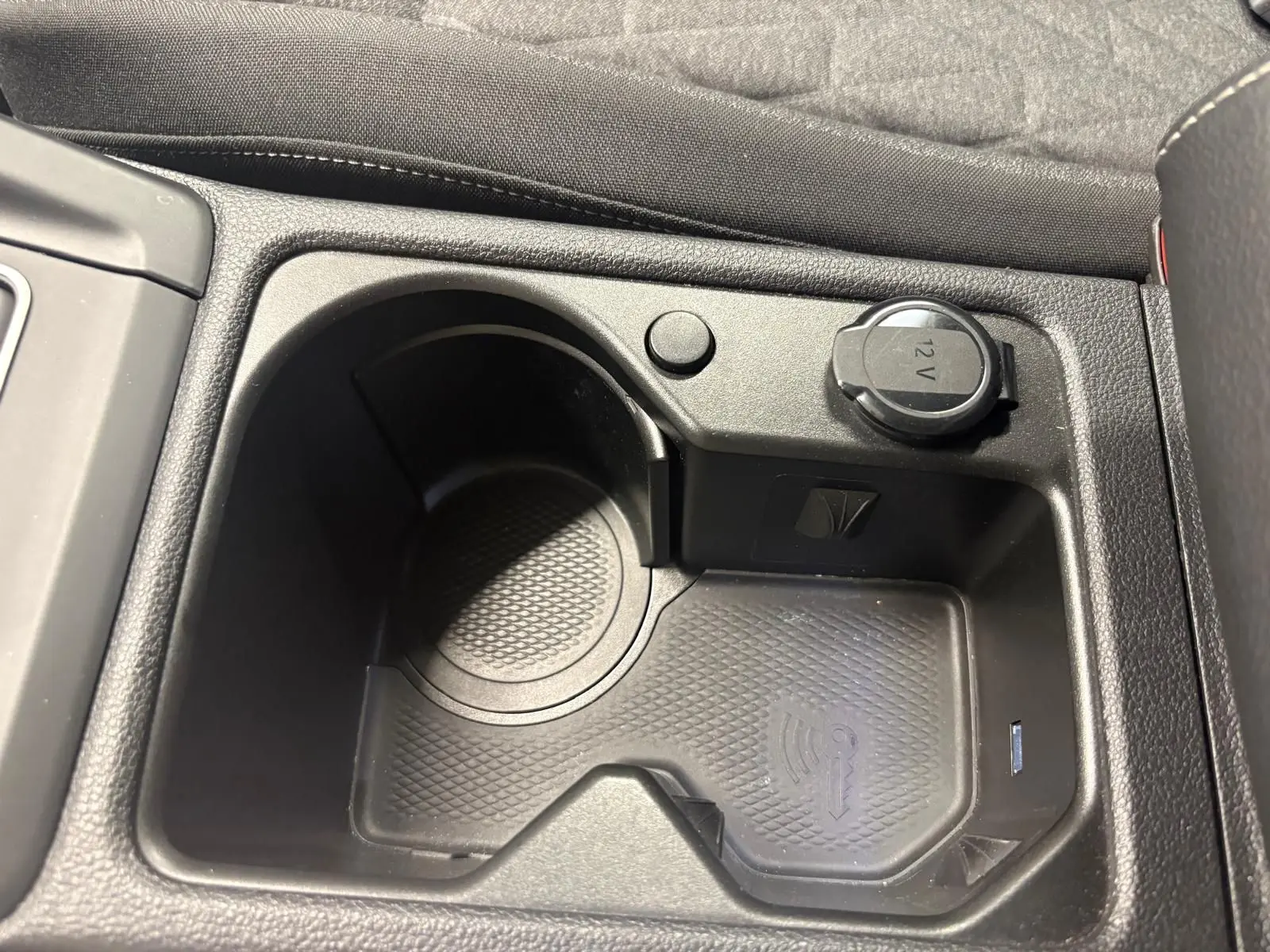 Gros plan sur la console centrale avec prise 12V et emplacement porte-gobelet du Volkswagen Golf Bleu Anémone 2025.