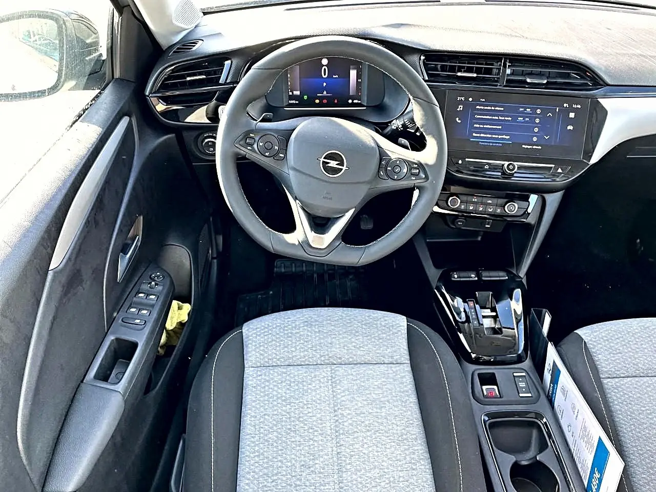 Vue intérieure avant de l’Opel Corsa 1.2 turbo 100 edition bva8, volant multifonction gris, sièges tissu clair et écran tactile.