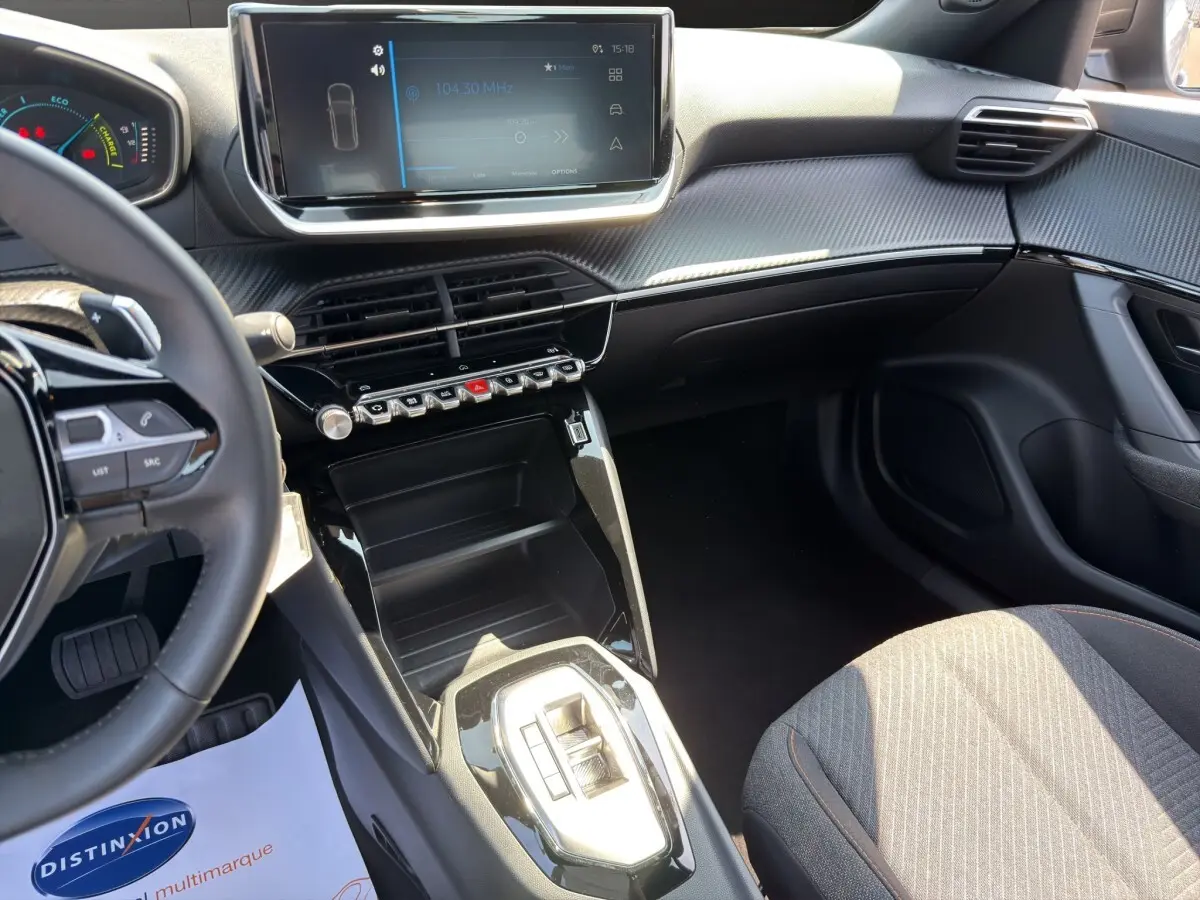 Vue intérieure côté conducteur du Peugeot 2008 Hybrid 145 e-DCS6 STYLE 2025, tableau de bord noir avec écran tactile central.