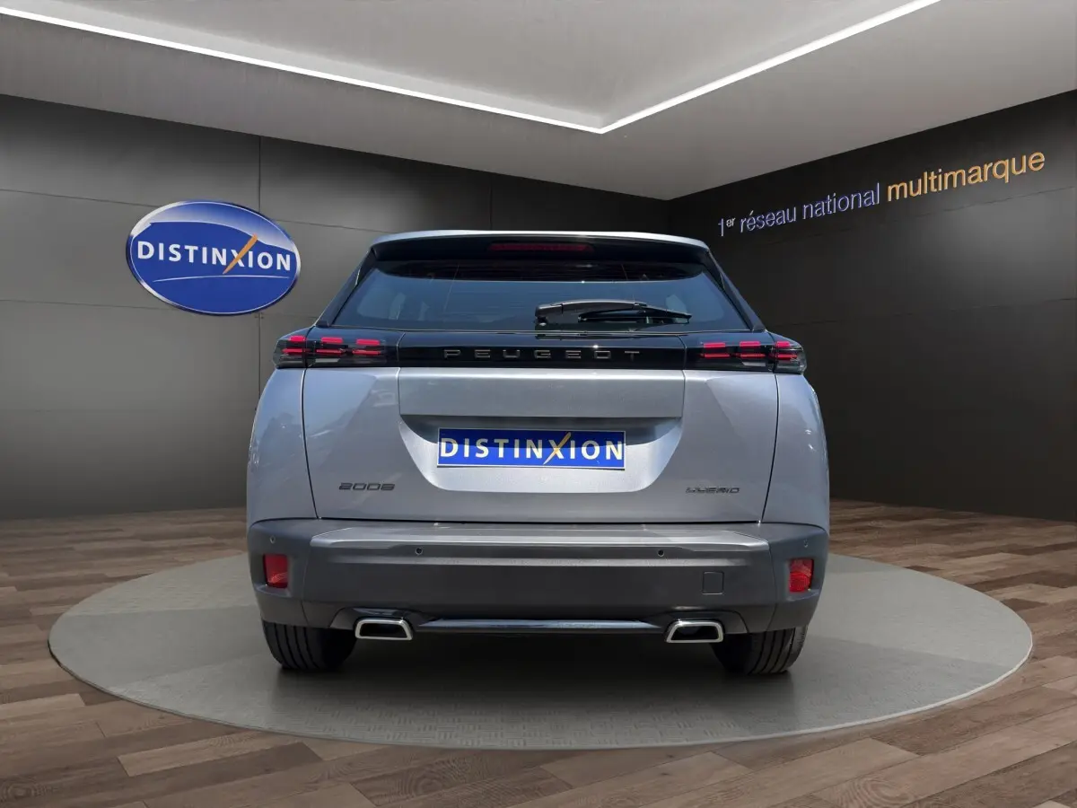 Vue arrière d'un Peugeot 2008 Hybrid gris clair avec feux LED distinctifs et double sortie d'échappement.