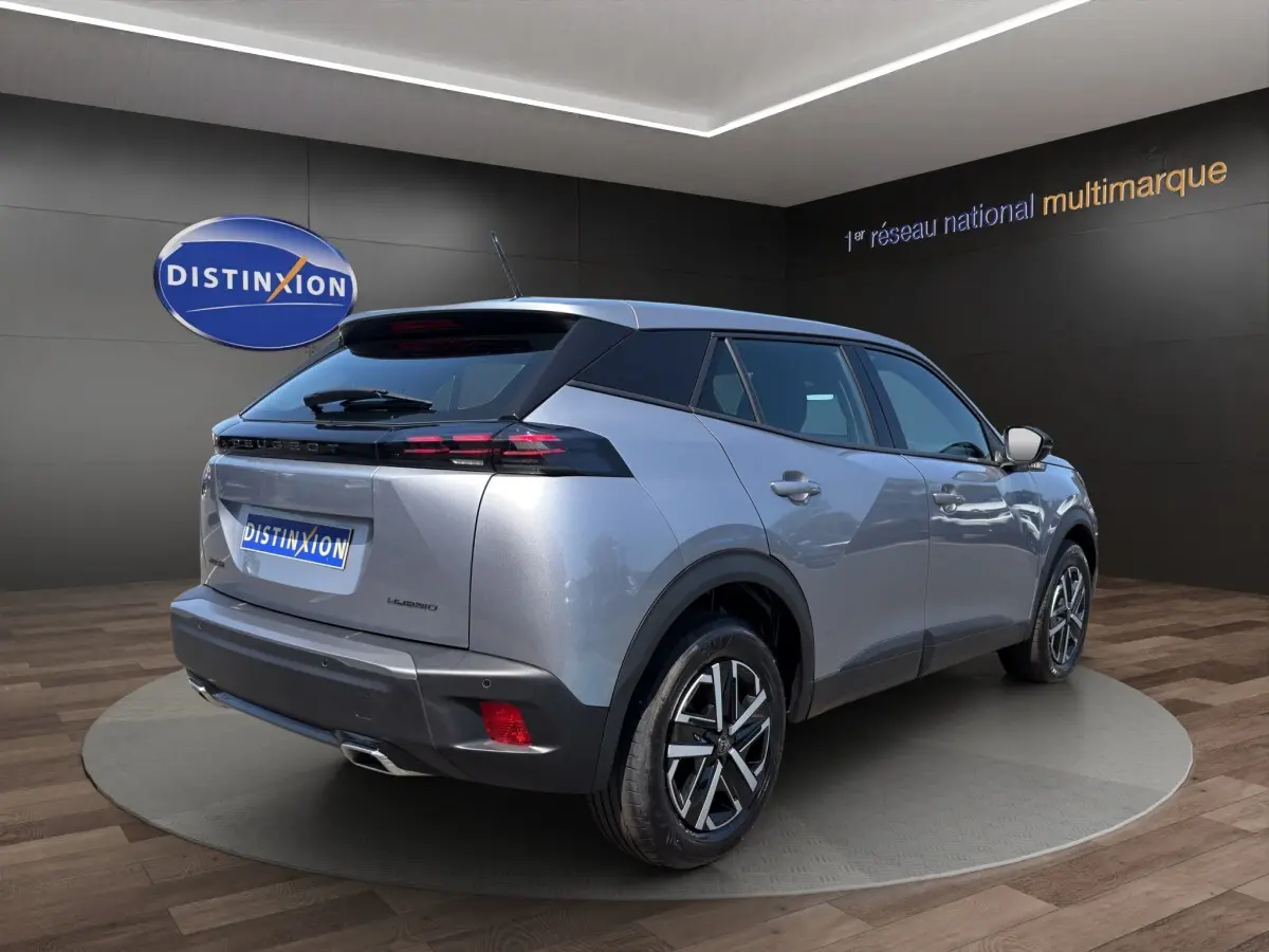 Peugeot 2008 Hybrid gris clair vue 3/4 arrière droit, feux LED et jantes alliage distinctives visibles.