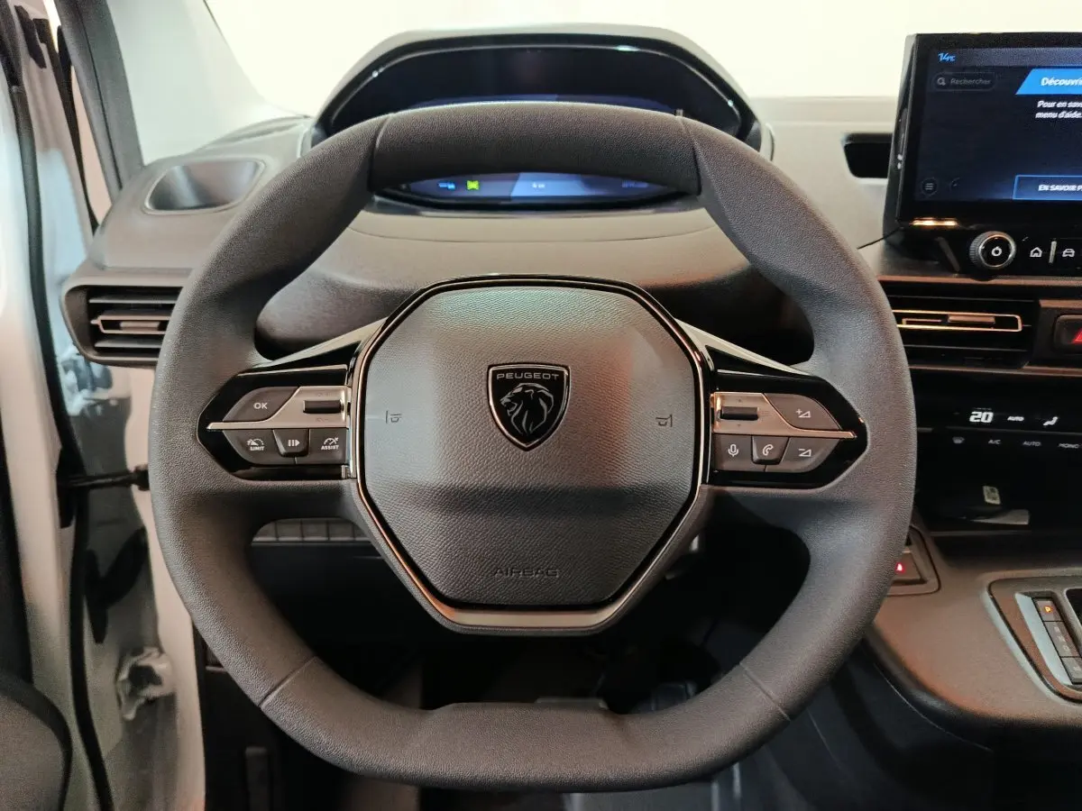 Vue rapprochée du volant multifonction noir du Peugeot Partner XL 2025 avec tableau de bord numérique et écran tactile.