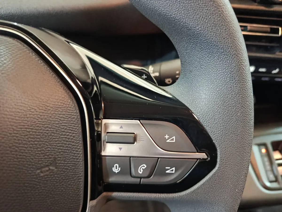 Gros plan sur les commandes multifonctions noires du volant du Peugeot Partner XL blanc 2025.