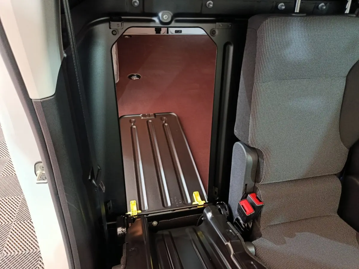 Vue intérieure côté gauche du siège avant du Peugeot Partner XL blanc, montrant la cloison pleine et l'espace de chargement.