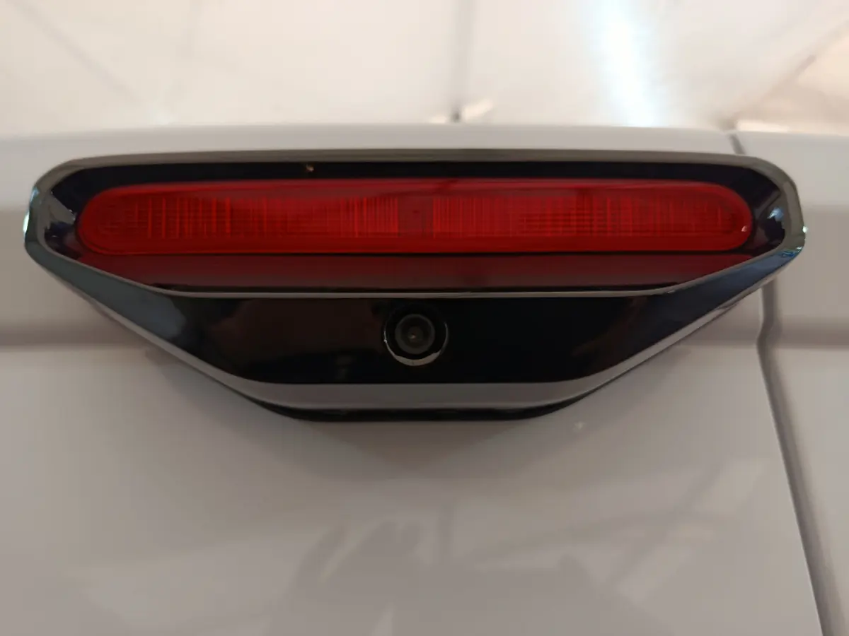 Gros plan sur le feu stop rouge et la caméra de recul intégrée sur la porte arrière blanche du Peugeot Partner XL 2025.