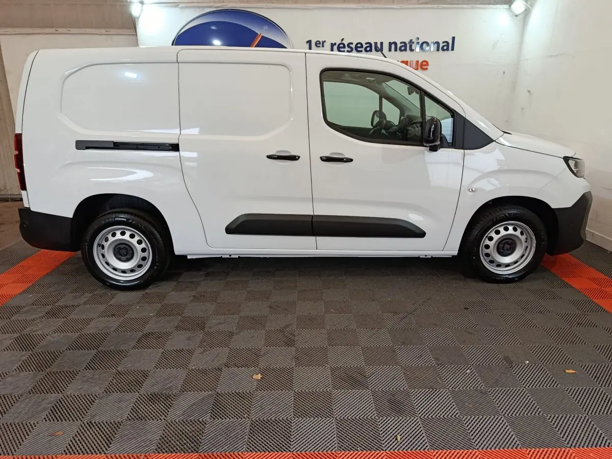 Profil droit du Peugeot Partner XL blanc 2025, utilitaire avec portes latérales et jantes acier simples.