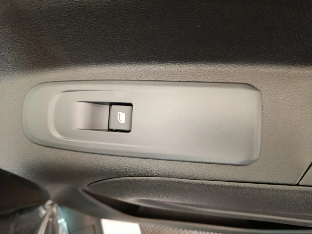 Gros plan sur le bouton de commande de la vitre électrique côté conducteur du Peugeot Partner XL blanc 2025.