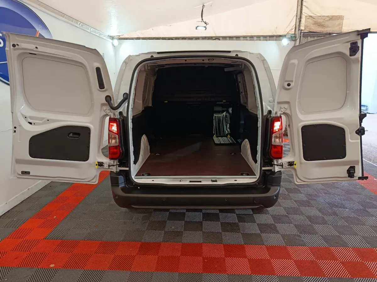 Vue arrière du Peugeot Partner XL blanc 2025 avec portes ouvertes et grand espace de chargement vide.