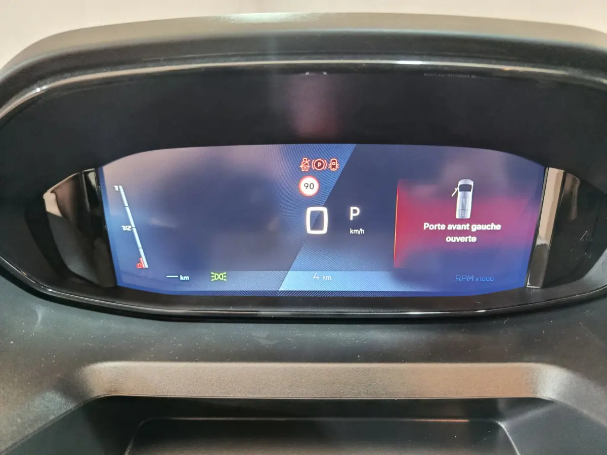 Tableau de bord numérique du Peugeot Partner XL 2025 affichant porte avant gauche ouverte et vitesse à zéro km/h.