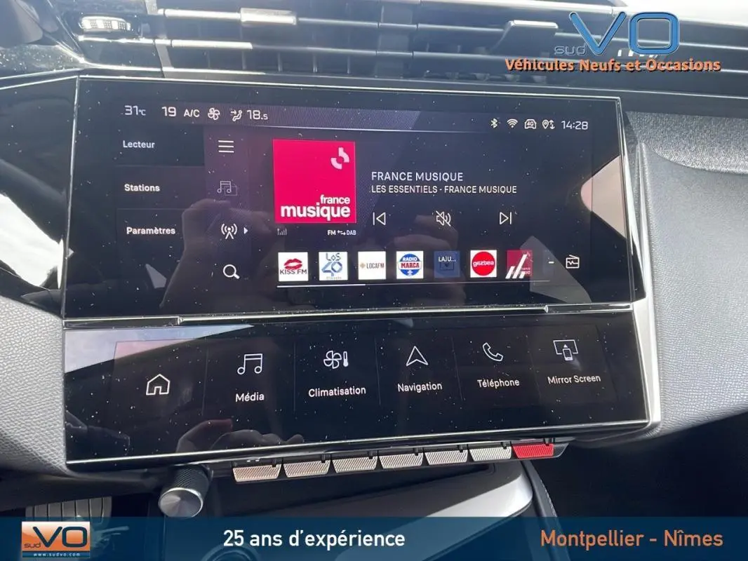 Vue rapprochée du tableau de bord tactile de la Peugeot 308 gris 2024, affichant l’interface multimédia France Musique.