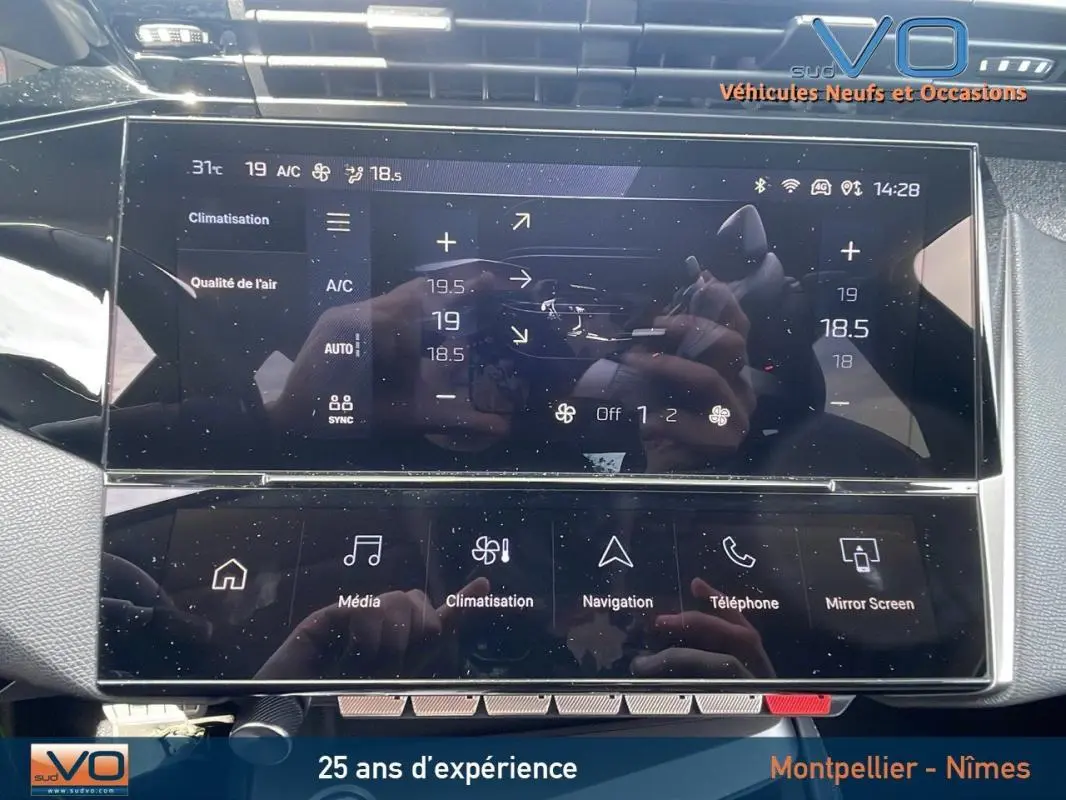 Écran tactile central de la Peugeot 308 gris 2024 montrant les réglages de climatisation et multimédia.