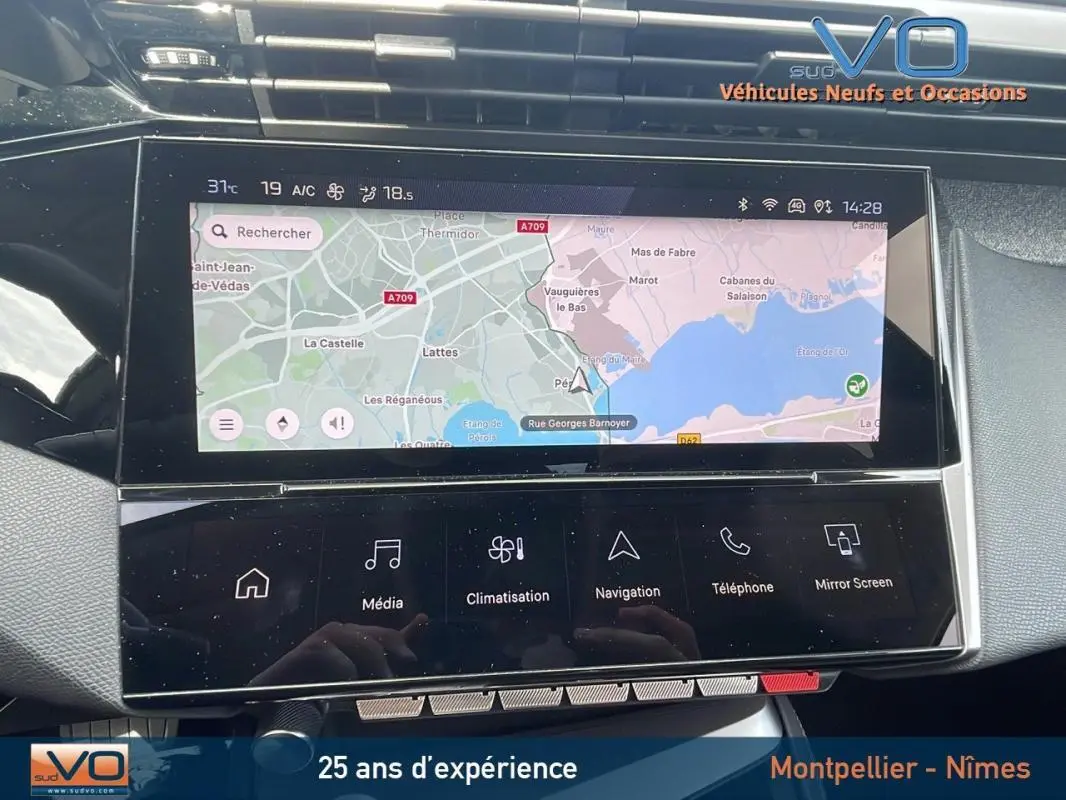 Vue rapprochée de l'écran tactile central du Peugeot 308 gris 2024, affichant la navigation GPS et commandes multimédia.