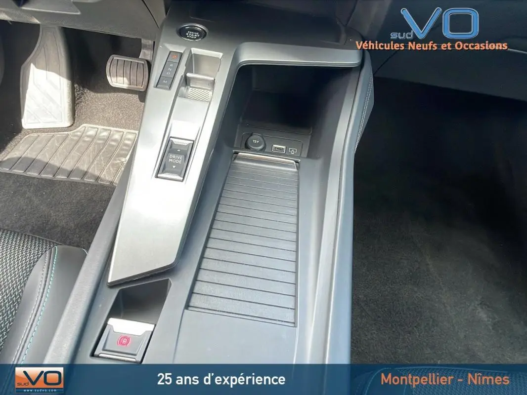 Vue rapprochée de la console centrale grise de la Peugeot 308 2024 avec boîte auto et commandes modernes.