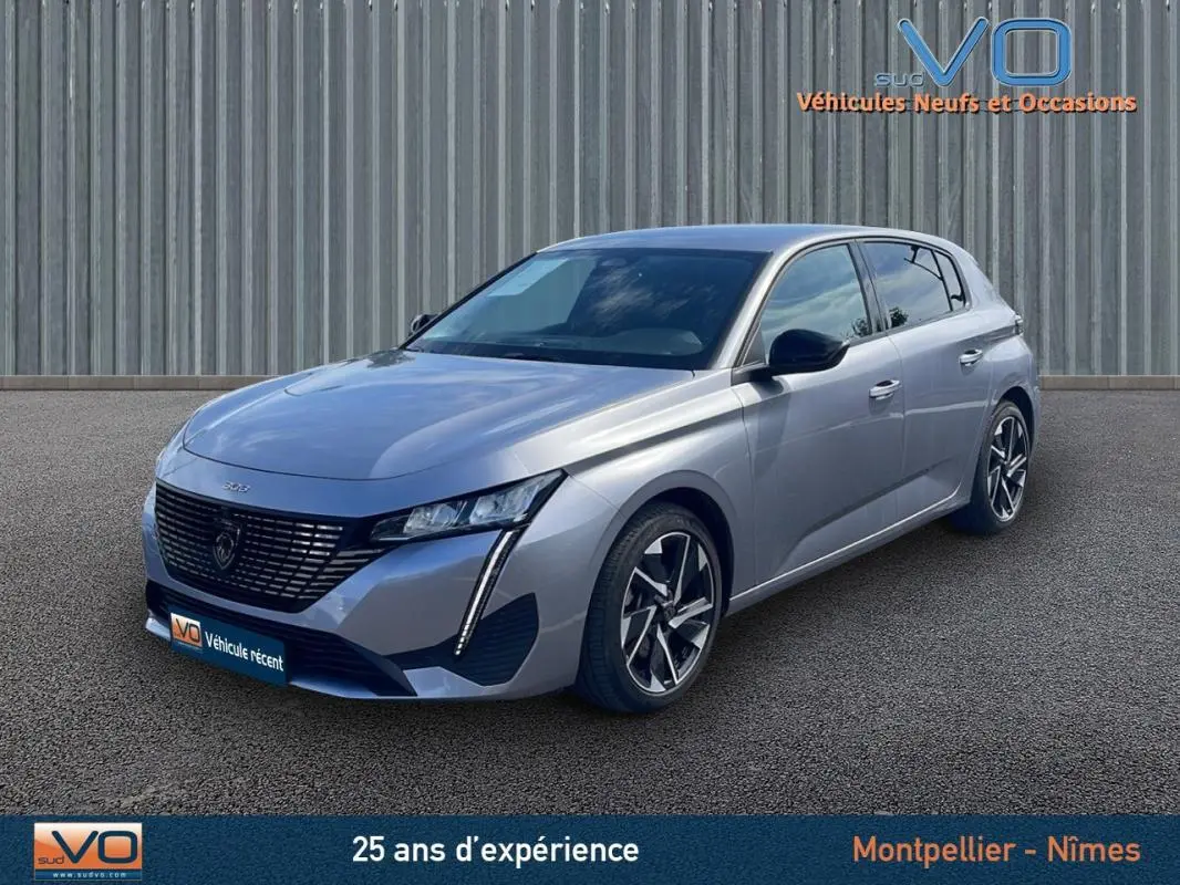 Peugeot 308 gris 2024 vue 3/4 avant, mettant en valeur sa calandre distinctive et ses jantes modernes.