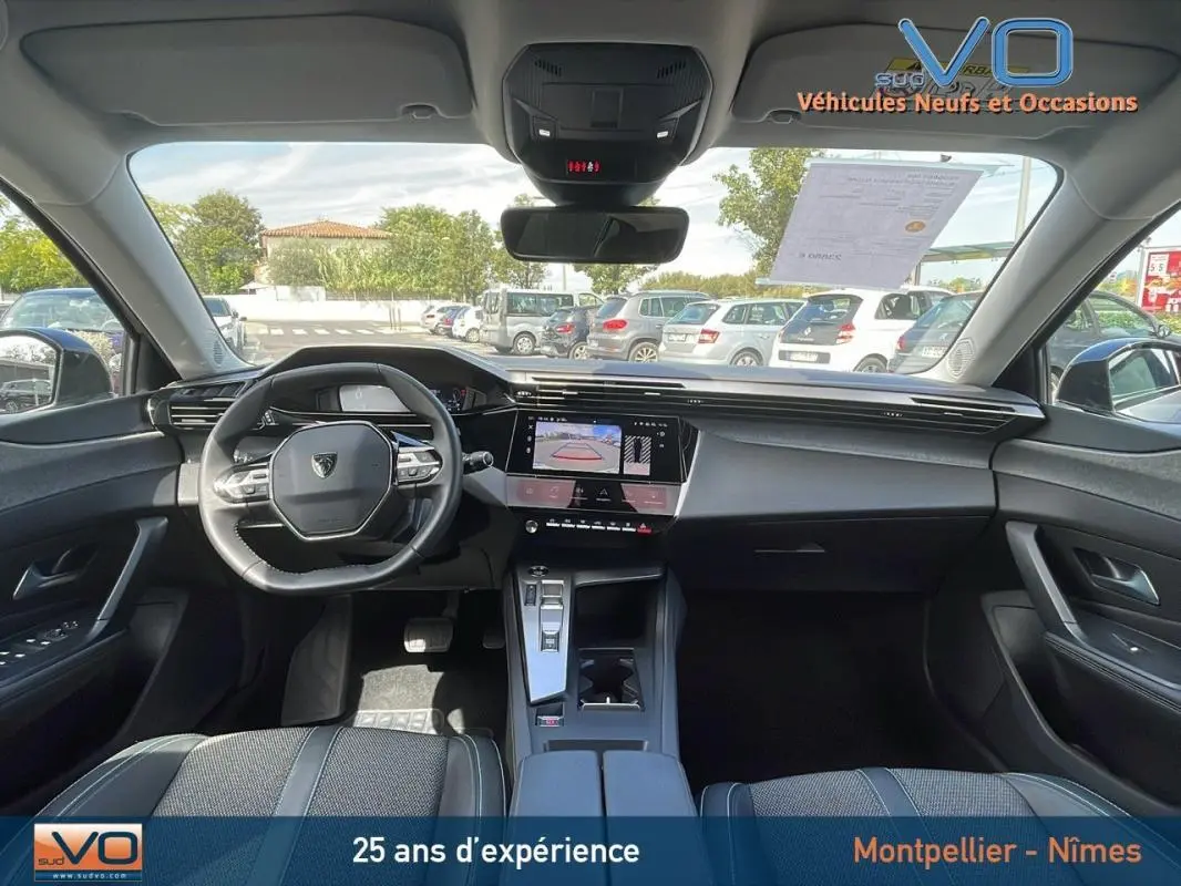 Vue intérieure avant de la Peugeot 308 gris 2024, avec volant compact, écran tactile et console centrale moderne.