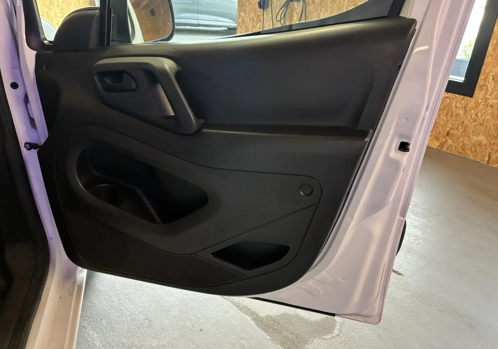 Vue rapprochée de la porte arrière gauche noire du Citroën Berlingo blanc 2016, mettant en valeur la poignée et les rangements intégrés.