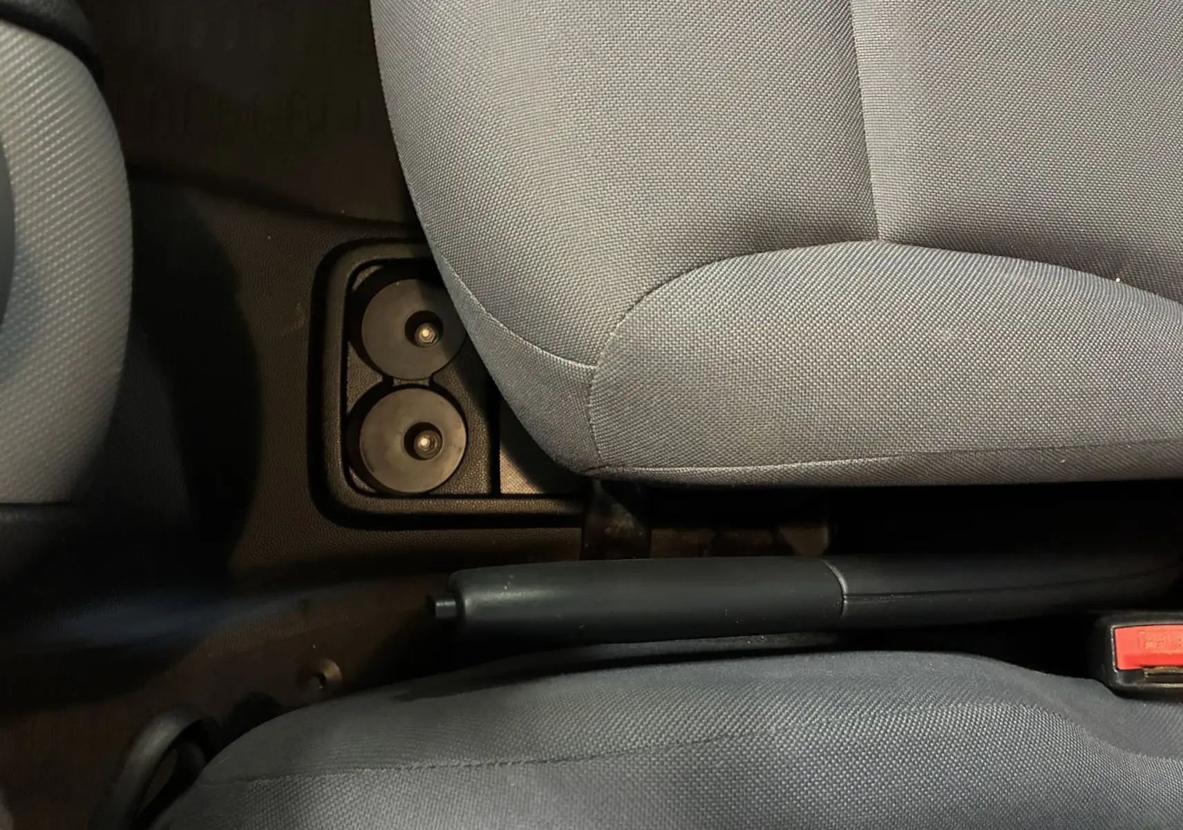 Vue rapprochée de l'intérieur du Citroën Berlingo 2016 montrant le frein à main entre les sièges en tissu gris.
