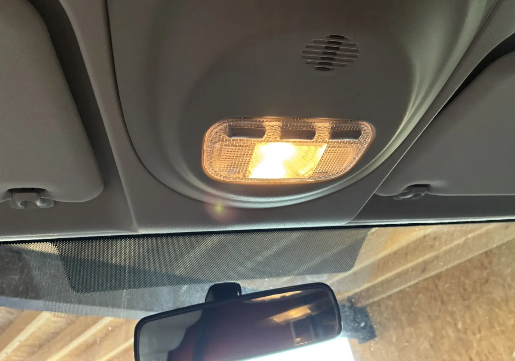Plafonnier intérieur allumé vu de dessous dans un Citroën Berlingo blanc 2016, avec rétroviseur central visible.