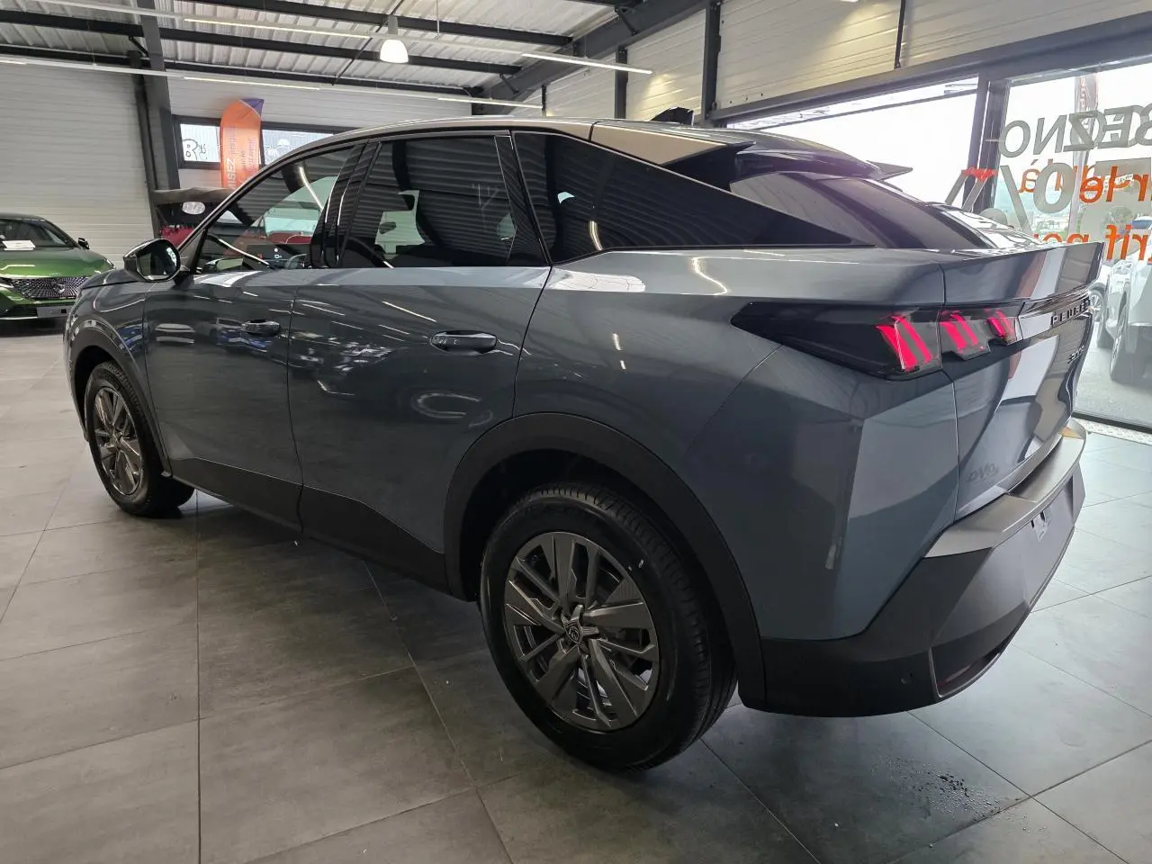 Vue 3/4 arrière droite du Peugeot 3008 hybride bleu avec feux arrière à LED 3 griffes et jantes alliage 18 pouces Basel.