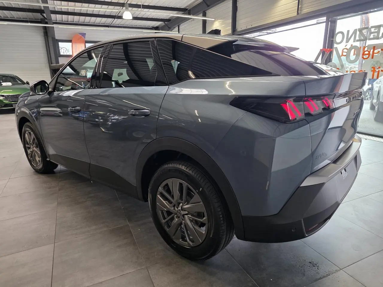 Vue 3/4 arrière droite du Peugeot 3008 hybride bleu métallisé avec feux arrière à LED en forme de griffes.
