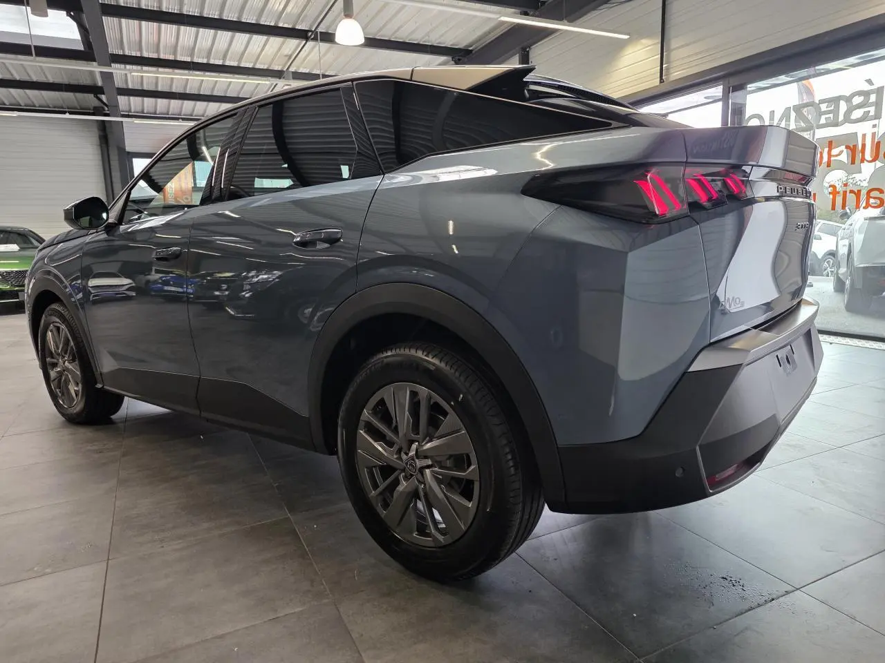 Vue 3/4 arrière droite du Peugeot 3008 hybride bleu avec feux arrière à LED en forme de griffes et jantes alliage 18 pouces.