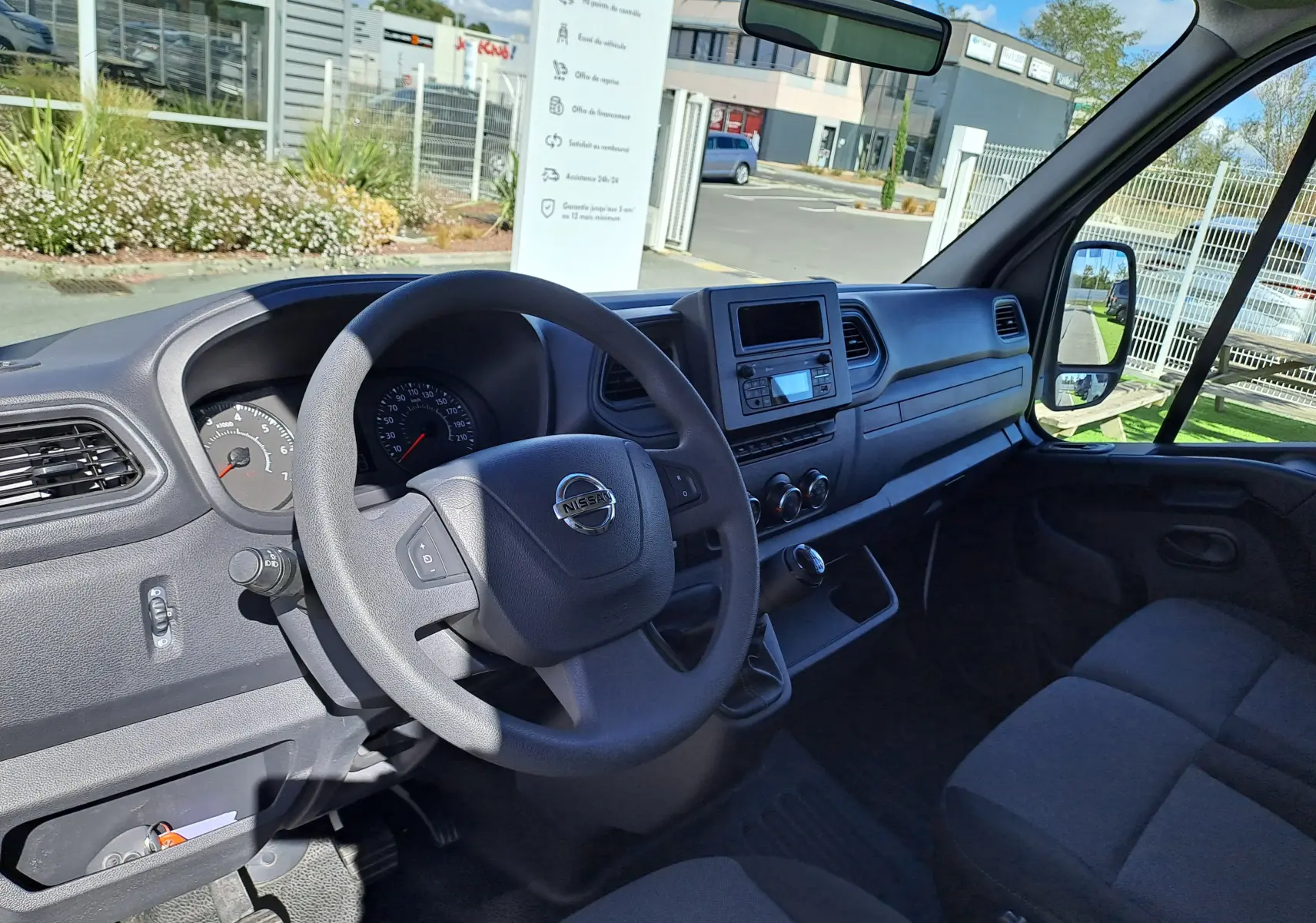 Vue intérieure côté conducteur du Nissan Interstar Chassis Cabine blanc 2024, tableau de bord et volant visibles.